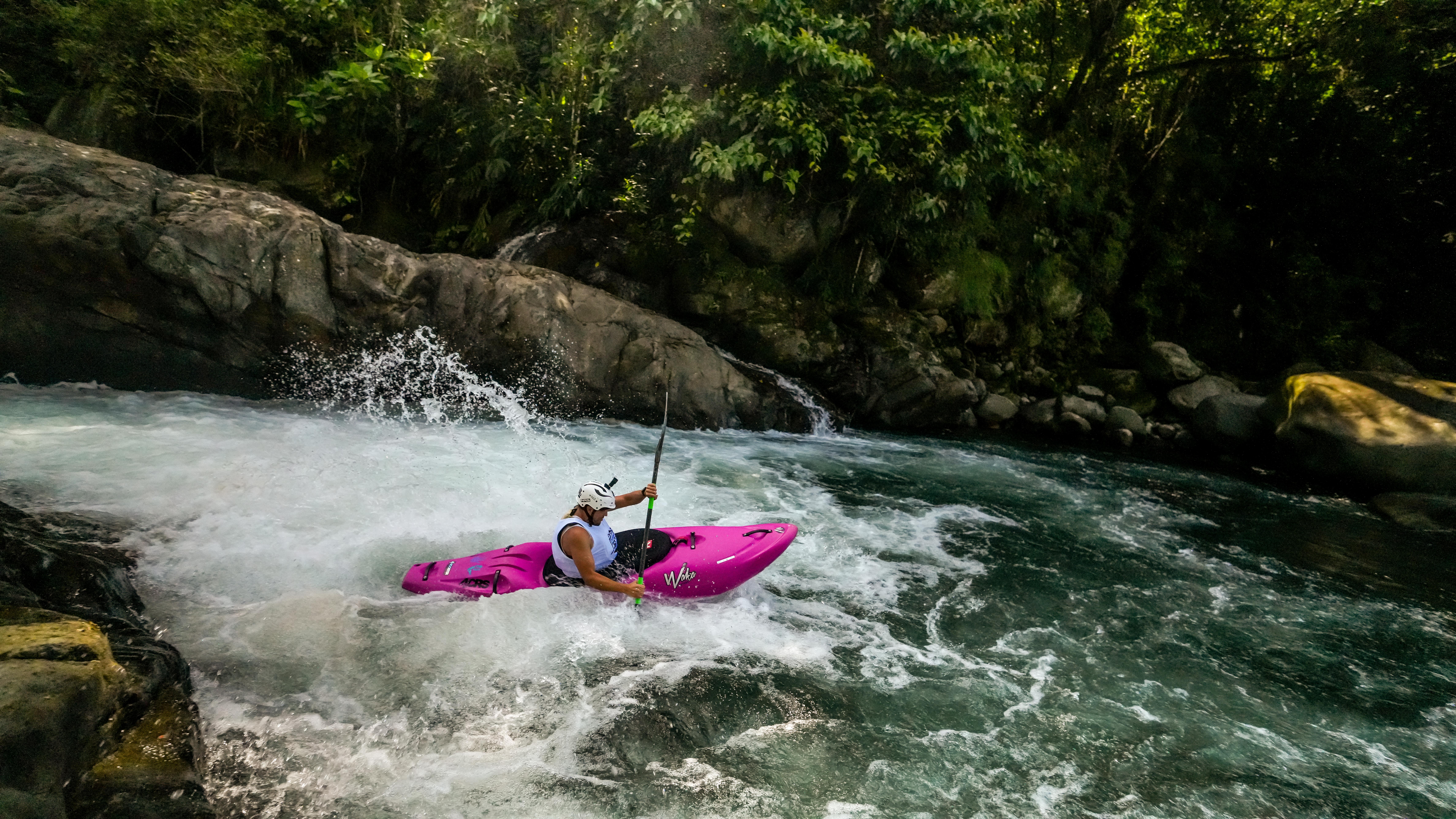 Pink kayak dropping a rapid