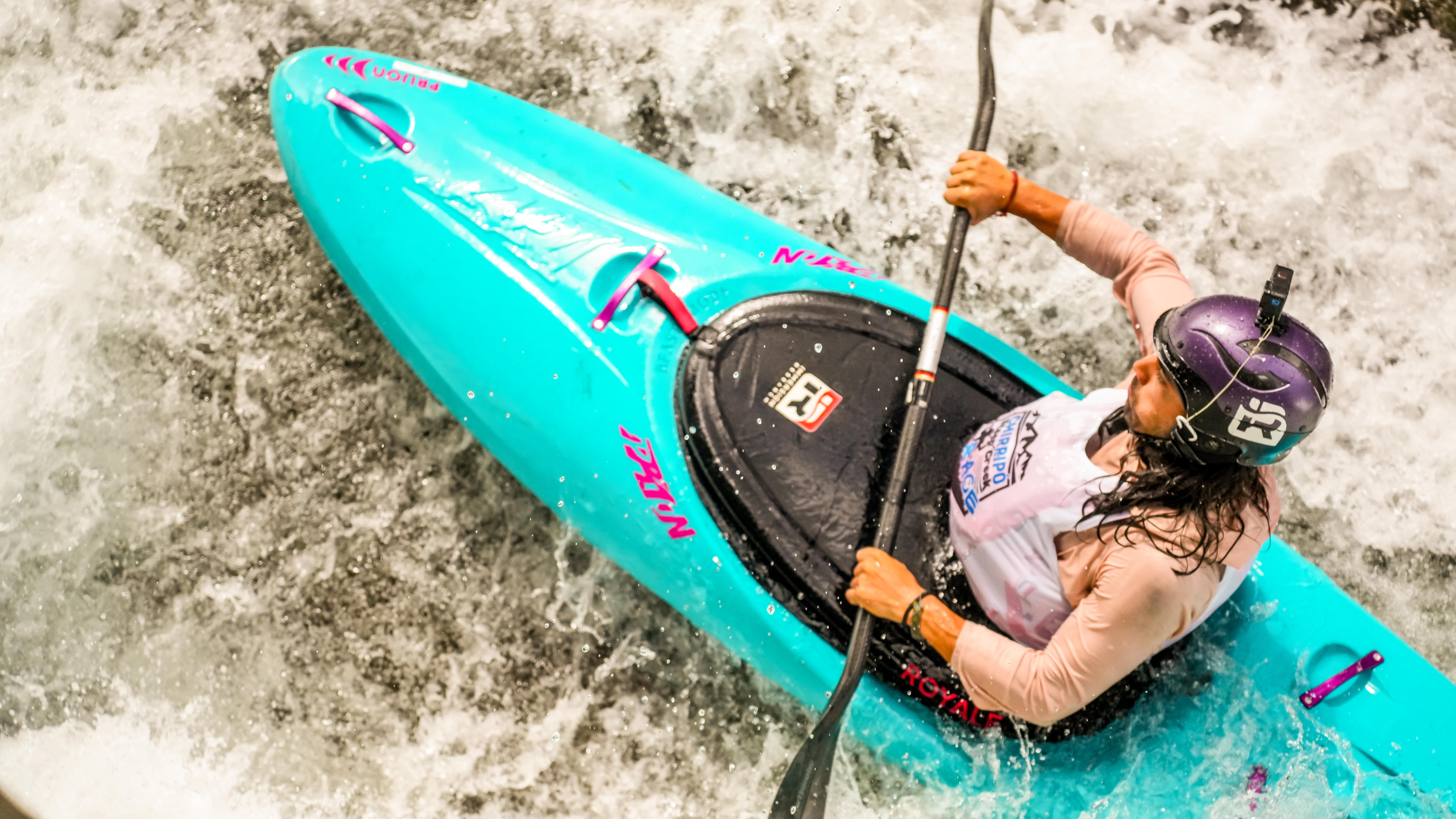 Teal kayak in whitewater